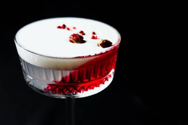 Alcoholic drink. A cocktail with elite alcohol on dark black background, close-up. Concept of  nightlife and exotic drinks.