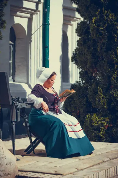 Esmer kadın portresi. Tarihi Barok kıyafetler giymiş. Eski moda saç stili, açık havada. İşçi sınıfı ortaçağ elbisesi