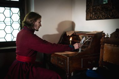 Orta çağ orta sınıf kostümü giymiş bir adamın portresi. Retro tarzı ve tarihi kıyafet kavramları. 18. yüzyılın erkek modası.