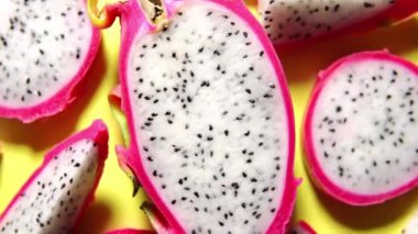 Taze beyaz pitaya dilimleri ya da sarı arka planda ejderha meyvesi, düz. Egzotik tropik ve vejetaryen gıda kavramı. 360 derece döndürme