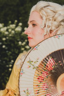 Sarışın kadın portresi. Tarihi Barok kıyafetler giymiş. Eski moda saç stili, açık havada. Lüks ortaçağ elbisesi