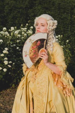 Sarışın kadın portresi. Tarihi Barok kıyafetler giymiş. Eski moda saç stili, açık havada. Lüks ortaçağ elbisesi