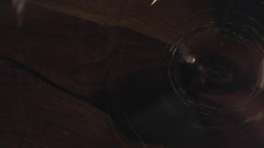 Pouring red wine into wineglass, close-up, selective focus. Slow motion 