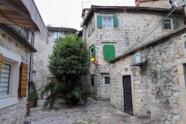 Kotor 'un dar kaldırımlı caddeleri ve UNESCO' nun Dünya Mirası adlı tarihi taş evleri. Eski şehir mimarisi detayları.