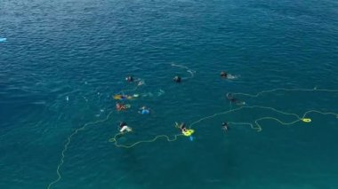 Fishermen divers set up fishing nets in the sea to catch fish on local island in Maldives. Aerial drone view