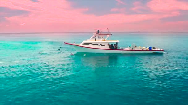 在马尔代夫的乌库尔斯岛 渔民们乘坐着一艘白色的船在日落时分 空中无人驾驶飞机俯瞰蓝绿色大海 — 图库视频影像