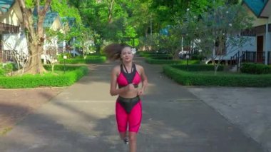 Sağlıklı kadın koşusu ve açık hava parkında spor yaparken hava görüntüsü. Asyalı koşucular spor yapıyor, doğa parkı geçmişi var. Sağlık ve Yaşam Tarzı Konsepti