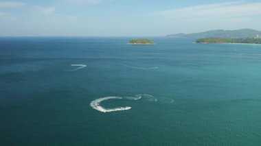 Zümrüt berrak sularda uçan jet ski manzarası.