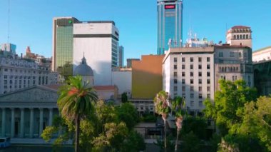 Buenos Aires 'in tarihi ve modern binaları, yemyeşil alanları ve açık mavi gökyüzüyle hava manzarası.