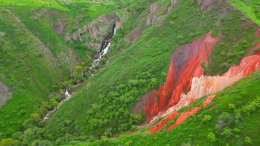 Kazakistan 'daki göz kamaştırıcı kırmızı kanyon, bereketli yeşilliğe karşı canlı renkler içeriyor ve sarmal bir nehir manzarayı güzelleştiriyor..