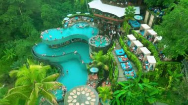 Bereketli yeşilliklerle çevrili birden fazla yüzme havuzunun bulunduğu canlı bir havuz Tegalalang, Ubud, Bali 'deki ziyaretçilere rahatlama ve dinlenme olanağı sunuyor..