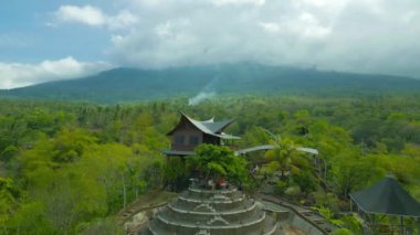 Bali 'de yemyeşil yemyeşil bir kulübe, eşsiz bir mimari ve bulutlu gökyüzünün altında sakin bir atmosferi var..
