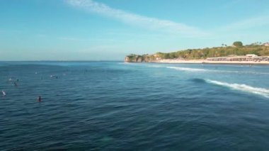 Bali 'deki Balangan Sahili' nin sakin suları ve kıyıda sörf yapan insanların hava manzarası..