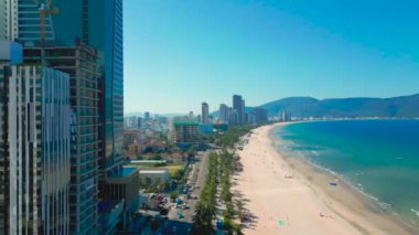 Da Nang 'daki My An Beach' in canlı görüntüsü kumlu kıyı şeridi, berrak sular ve kıyı boyunca modern gökdelenler sergiliyor..