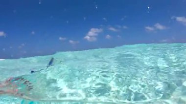 Bora Bora 'nın kumlu kıyıları yakınlarındaki berrak sularda bir cam şişenin su altında görüntüsü.