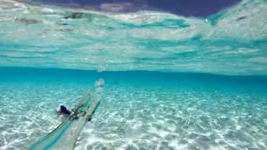 Maldivler 'deki su altı sahnesi berrak turkuaz suyla görülebilir kabarcıklar cam şişeden yüzeye doğru yükseliyor..