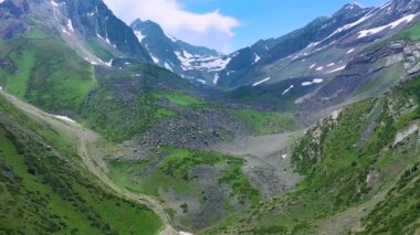 Yeşil yamaçlı bir dağ vadisi, kayalık arazi, karlı tepeler ve İsviçre 'nin Fahlensee yakınlarındaki bir dere manzarası..