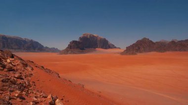 Büyük kum taşı oluşumları ve geniş boş uzayı olan kızıl çöl manzarası Wadi Rum, Ürdün 'de berrak bir gökyüzü altında.