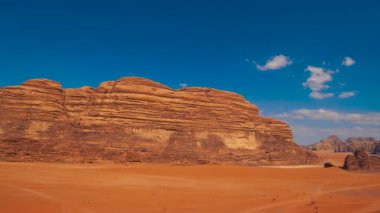 Mars 'ın yüzeyine ya da kızıl bir gezegene benzeyen mavi gökyüzünün altında büyük kırmızı kaya oluşumları olan çöl manzarası..