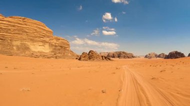 Yüksek kaya oluşumlarıyla çöl manzarası ve mesafeye uzanan bir patika Wadi Rum, Ürdün.