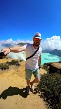 Kawah Ijen volkanı, Endonezya 'nın turkuaz asitli gölüne bakan bir adamın POV fotoğrafı..