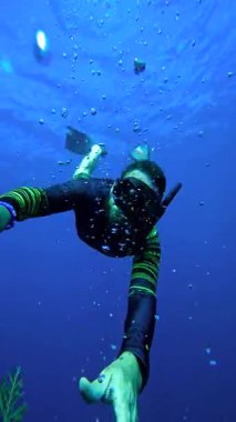 Şnorkel maskesi takan bir erkek dalgıç ve yüzgeçler Tulamben, Bali, Endonezya 'daki USAT Özgürlük gemisinin mercan kaplı yapısının yakınında yüzüyor..