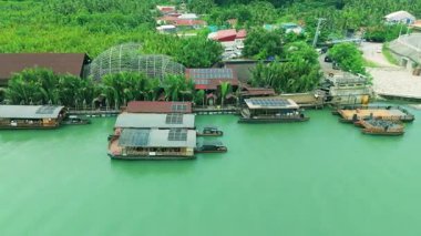 Palmiye ağaçları, evler, Loboc Nehri, Bohol ve Bohol ile çevrili yeşil bir nehir üzerinde yüzen restoranların hava manzarası..