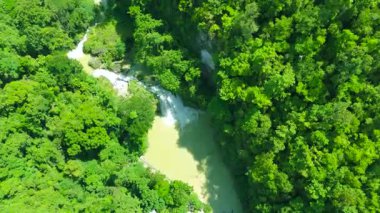 Kawasan Şelalesi, Cebu, Filipinler 'deki yemyeşil tropikal bir ormandan akan çok katmanlı şelale ve nehrin havadan görünüşü..