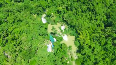 Çok katmanlı Kawasan Şelalesi 'nin ve turkuaz nehrinin havadan görünüşü. Filipinler' in Cebu kentindeki yemyeşil tropikal ormanda çağlıyor..