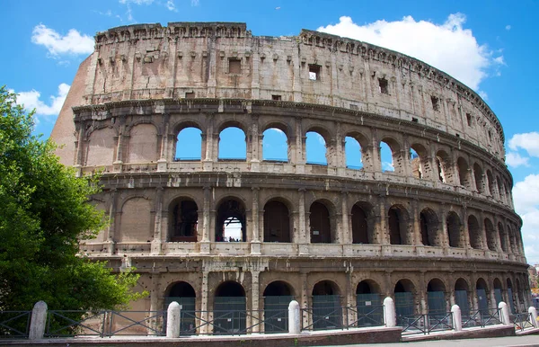 stock image The photo shows the Colosseum, an iconic landmark of ancient Rome, in the afternoon. The sun casts a warm golden light on the ancient stone structure, highlighting its intricate arches and columns.