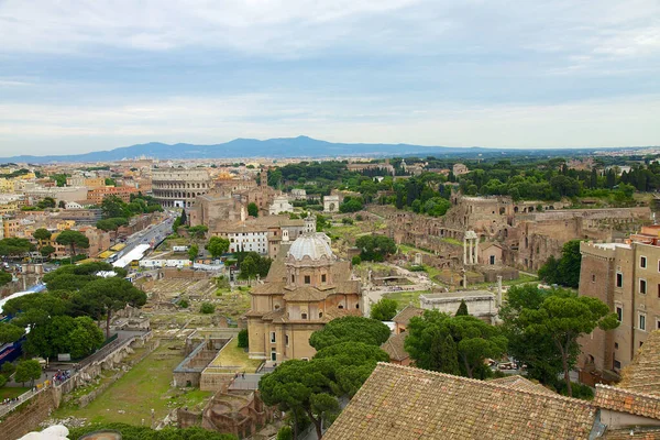 Fotoğraf Roma Forumu 'nun ve antik Roma' nın iki simgesi olan Colosseum 'un panoramik görüntüsünü gösteriyor.. 