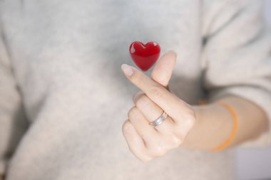 Gril 'in küçük kalbi aşk parmağı şeklini ve 3 boyutlu kırmızı kalbi gösteriyor.