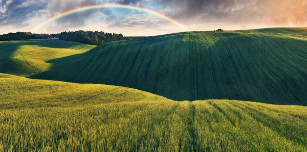 绿地上彩虹的景致 在风景如画的丘陵地带上的灰蒙蒙的天空 — 图库照片
