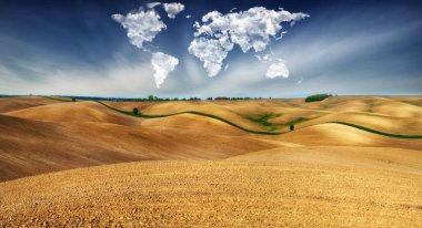 clouds in the form of a map of the world over the field. Travel and landscape concept. hilly field clipart