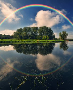 Landscape with a Rainbow on the River in Spring. colorful morning. nature of Ukraine