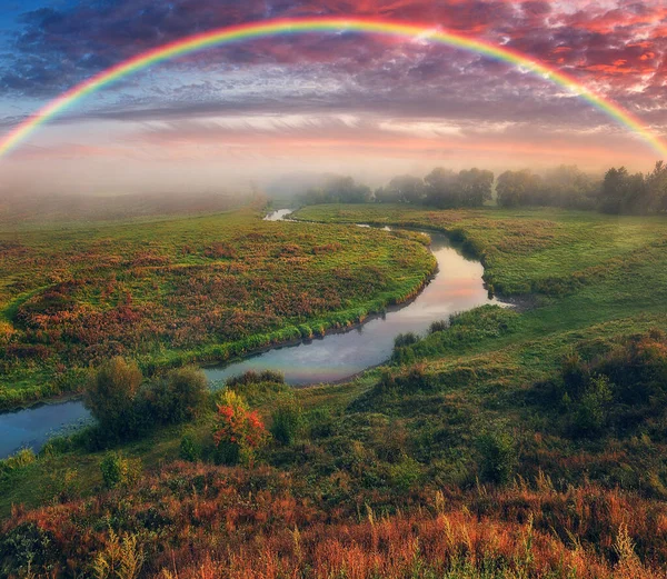 Amazing rainbow over the small rural river. autumn morning. nature of Ukraine
