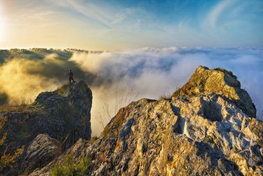 Kadın nehir kanyonunun üstündeki bir kayanın üzerinde duruyor. Dişi turistler sisli sonbahar manzarasının tadını çıkarırlar. Ukrayna 'nın doğası
