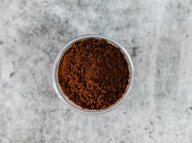  Arka planda çözünmüş cam kasede yakın çekim kahve tozu..