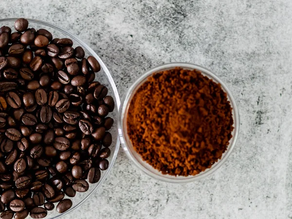 stock image Coffee beans served in saucer with defocused coffee powder.