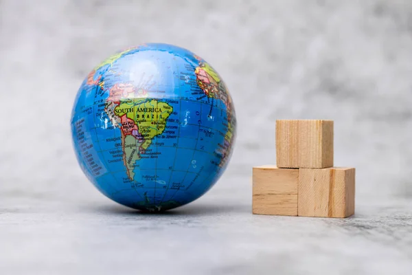 stock image Close up shot of globe placed with wooden blocks on defocused background.