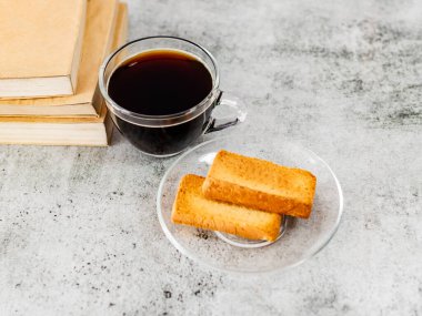Yüksek açılı sade kahve, yanında kitaplar ve sauc rusk.