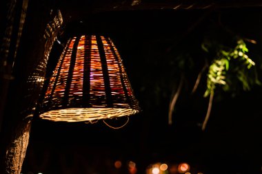 Ağaçtan sarkan güzel bir sepet tipi ışık ve arka planda bokeh..