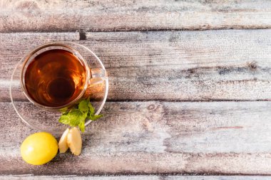 Nane yapraklı, limonlu, ahşap yüzeye yerleştirilmiş zencefil dilimli en iyi çay..