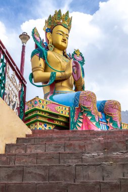  Leh, Hindistan - 16 Haziran 2022 - Mavi gökyüzü bulutlu dev Maitreya Buda heykelinin alçak açılı çekimi.