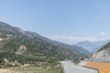 Nehir kıyısında bir dağ vadisi manzarası.