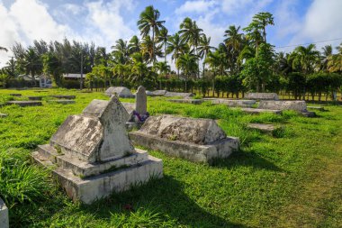 Tropikal bir adada küçük bir mezarlıkta eski mezar taşları. Rarotonga, Cook Adaları