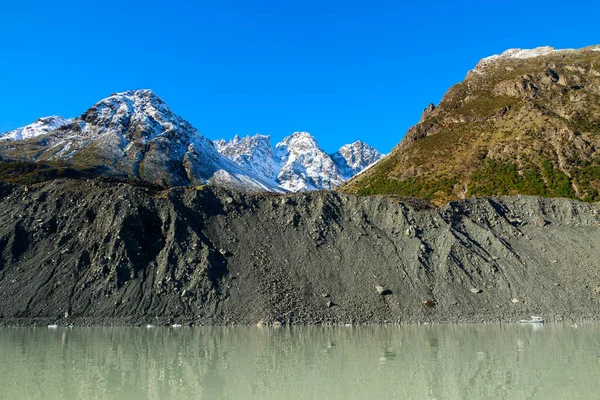 ニュージーランド南島のマウントクック国立公園のタスマン湖の端にある氷河の破片の壁であるモレーン — ストック写真