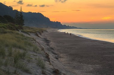 Matata Sahili, Bolluk Körfezi, Yeni Zelanda, gün batımında, uzak balıkçılarla