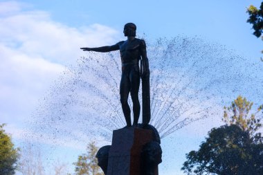 Hyde Park, Sydney, Avustralya 'daki tarihi Archibald Çeşmesi. Apollo 'nun siluetli figürü, arkasında su püskürten jetler. 