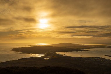 Blöf, Yeni Zelanda. Gün batımında Bluff Hill gözcüsünün manzarası. Düz Tepe rüzgâr çiftliğinin türbinleri solda görünüyor ve Bluff köyü de sağ altta yer alıyor.  